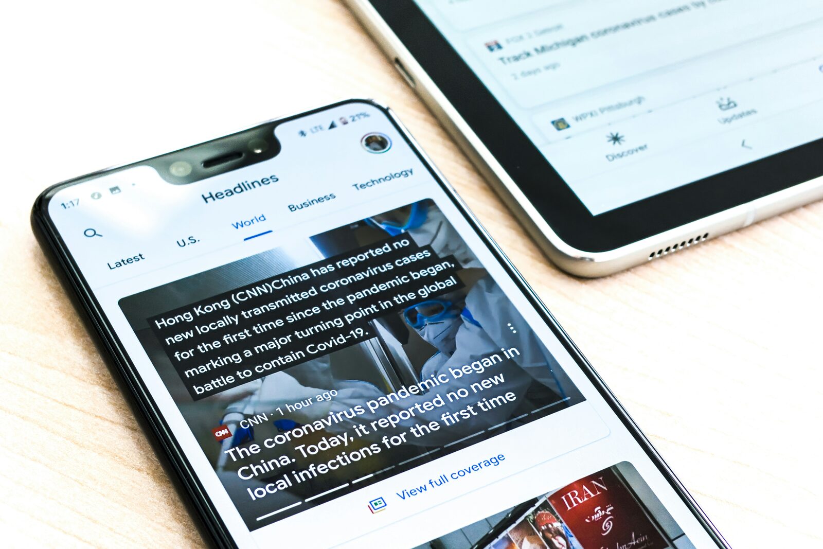 Ein Smartphone zeigt eine Nachrichtenübersicht mit Schlagzeilen, daneben ein Tablet.